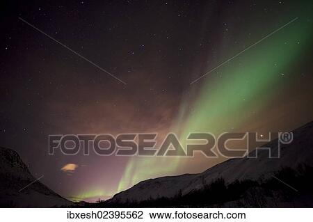 Stock Image - "Northern Lights over the Kattfjord pass in winter, Kvaloya, Tromso, Norway, Europe". Fotosearch