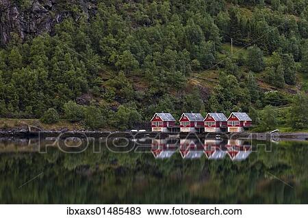Stock Image - "Norwegian houses reflected in the Aurlandsfjord, Flam, Norway, Scandinavia, Europe". Fotosearch
