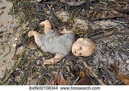 Old broken doll lying in the dirt on the ground View Large Photo Image Picture - Old broken doll lying in the dirt on the ground. Fotosearch