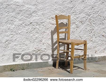 Old chair in front of a wall View Large Photo Image Stock Photograph - Old chair in front of a wall. Fotosearch