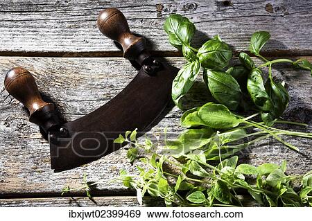 Old chopping knife with different herbs on a rustic wooden table View Large Photo Image Stock Photo - Old chopping knife with different herbs on a rustic wooden table. Fotosearch