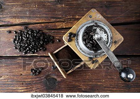 Old coffee grinder with coffee beans on a wooden surface View Large Photo Image Stock Photo - Old coffee grinder with coffee beans on a wooden surface. Fotosearch