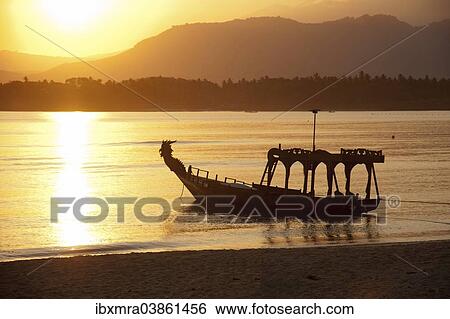 Stock Photograph - "Old fishing boat on the beach, at sunrise, near Pemenang, Lombok, Indonesia, Asia". Fotosearch