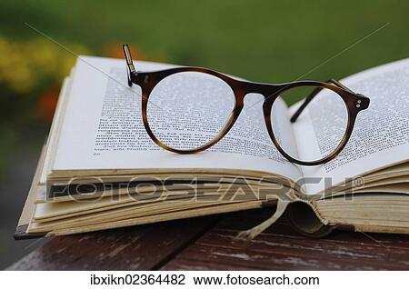 Old reading glasses with a book in the garden View Large Photo Image Stock Image - Old reading glasses with a book in the garden. Fotosearch