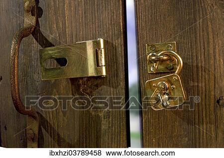 Stock Photo - Old wooden door with metal fittings and an open padlock. Fotosearch