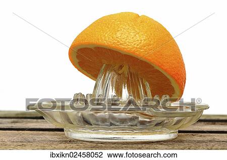 Stock Image - "Orange juicer made of glass, half an orange". Fotosearch