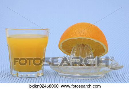 Stock Image - "Orange juicer made of glass, half an orange, freshly squeezed orange juice". Fotosearch