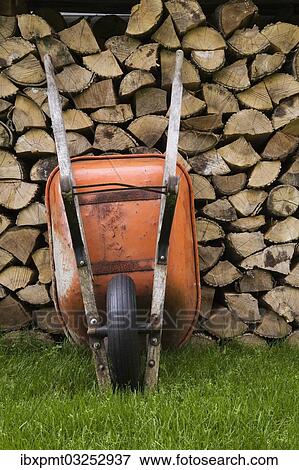"Orange wheelbarrow propped up against stacked firewood, Quebec City, Quebec Province, Canada, North America" View Large Photo Image Stock Photo - "Orange wheelbarrow propped up against stacked firewood, Quebec City, Quebec Province, Canada, North America". Fotosearch