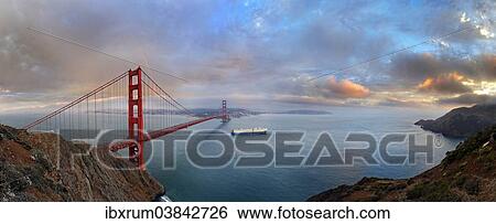 Stock Photograph - "Panoramic view of the Golden Gate Bridge at sunset with a rainbow and storm clouds, San Francisco, California, United States, North America". Fotosearch