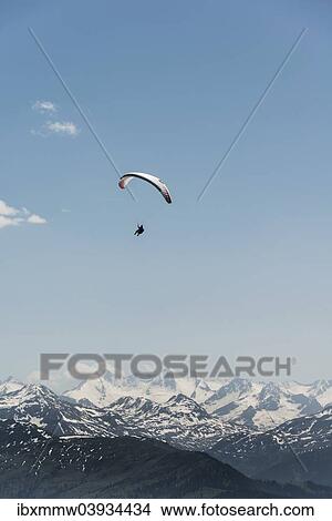 "Paraglider against a blue sky, snow-capped peaks of the Alps at the back" View Large Photo Image Picture - "Paraglider against a blue sky, snow-capped peaks of the Alps at the back". Fotosearch