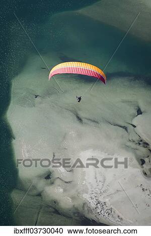 "Paraglider over the Maggia river delta with naturally formed water and rocks terrain, Locarno, Kanton Tessin, Switzerland, Europe" View Large Photo Image Stock Image - "Paraglider over the Maggia river delta with naturally formed water and rocks terrain, Locarno, Kanton Tessin, Switzerland, Europe". Fotosearch