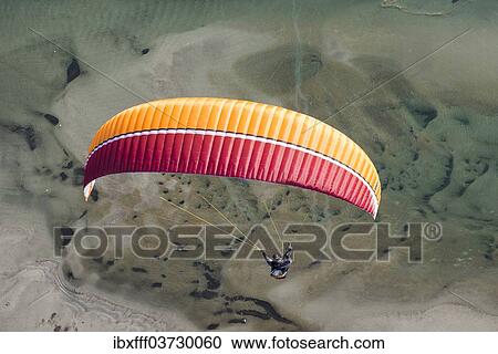 "Paraglider over the Maggia river delta with naturally formed water and rocks terrain, Locarno, Kanton Tessin, Switzerland, Europe" View Large Photo Image Stock Image - "Paraglider over the Maggia river delta with naturally formed water and rocks terrain, Locarno, Kanton Tessin, Switzerland, Europe". Fotosearch