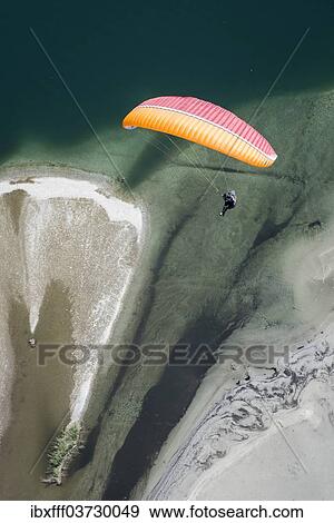 "Paraglider over the Maggia river delta with naturally formed water and rocks terrain, Locarno, Kanton Tessin, Switzerland, Europe" View Large Photo Image Stock Photo - "Paraglider over the Maggia river delta with naturally formed water and rocks terrain, Locarno, Kanton Tessin, Switzerland, Europe". Fotosearch