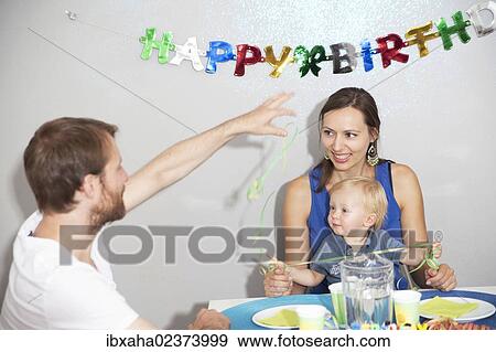Parents and a child at the child's birthday party View Large Photo Image Stock Photo - Parents and a child at the child's birthday party. Fotosearch