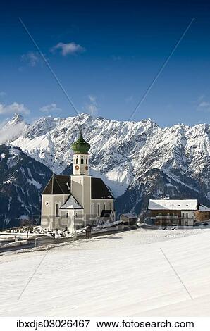 Stock Photo - "Parish and pilgrimage church of St. Bartholomew, Baroque church, in front of mountain range, Bartholomaberg, Montafon, Vorarlberg, Austria, Europe". Fotosearch