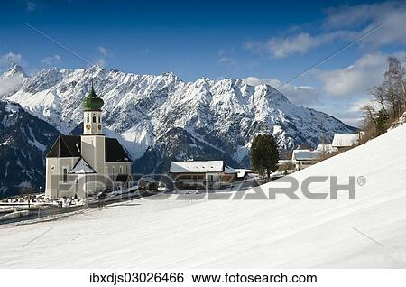 Stock Photograph - "Parish and pilgrimage church of St. Bartholomew, Baroque church, in front of mountain range, Bartholomaberg, Montafon, Vorarlberg, Austria, Europe". Fotosearch