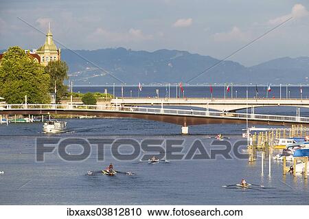 Stock Image - "Passenger ship and rowing boats on the Rhine River, looking towards Obersee lake and Pfander Mountain, Konstanz, Baden-Wurttemberg, Germany, Europe". Fotosearch