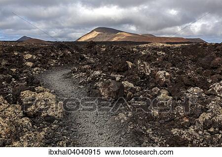 "Path through a lava field, volcanic landscape, Fire Mountains, volcanoes, Caldera Blanca volcano at the back, Lanzarote, Canary Islands, Spain, Europe" View Large Photo Image Stock Photography - "Path through a lava field, volcanic landscape, Fire Mountains, volcanoes, Caldera Blanca volcano at the back, Lanzarote, Canary Islands, Spain, Europe". Fotosearch
