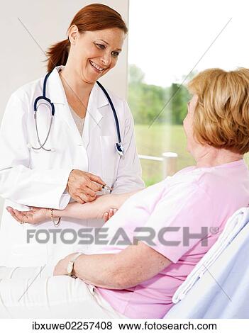 Patient getting a shot from her doctor View Large Photo Image Stock Photo - Patient getting a shot from her doctor. Fotosearch