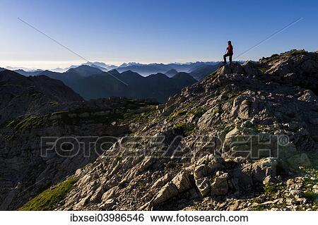 Stock Photograph - "Peaks of the Allgau Alps in the early morning with a hiker, Oberstdorf, Bavaria, Germany, Europe". Fotosearch
