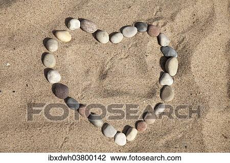 Pebbles in the sand forming a heart shape View Large Photo Image Stock Image - Pebbles in the sand forming a heart shape. Fotosearch