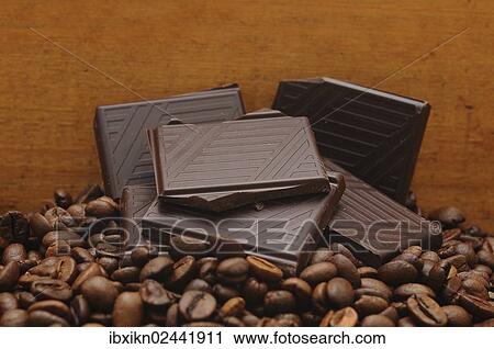 Stock Image - Pieces of chocolate on coffee beans. Fotosearch