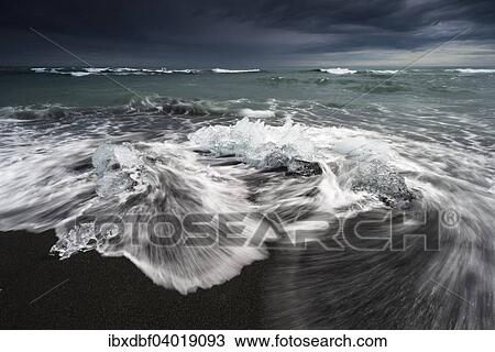 Stock Image - "Pieces of ice on the black beach lapped by the sea, at Jokulsarlon Glacial Lagoon, Vatnajokull Glacier, Eastern Region, Iceland, Europe". Fotosearch