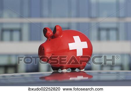 Stock Image - Piggy bank in front of the glass facade of a bank. Fotosearch