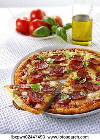 "Pizza topped with pepperoni, cheese, chili and basil with a slice out" View Large Photo Image Stock Image - "Pizza topped with pepperoni, cheese, chili and basil with a slice out". Fotosearch