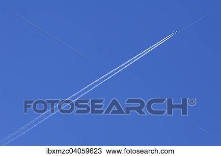 Plane with contrails against a blue sky View Large Photo Image Stock Image - Plane with contrails against a blue sky. Fotosearch