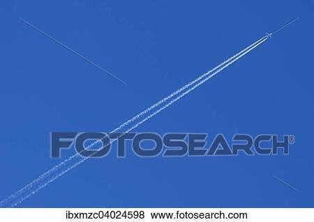 "Plane with contrails in the blue sky, Germany, Europe" View Large Photo Image Stock Photo - "Plane with contrails in the blue sky, Germany, Europe". Fotosearch
