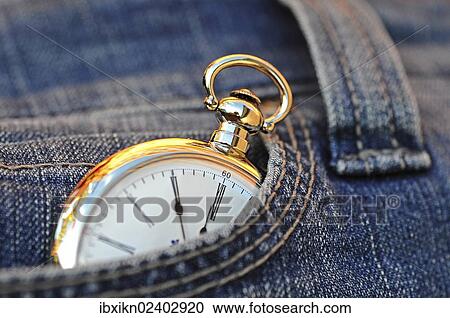 Stock Image - "Pocket watch in a jeans pocket, the eleventh hour, 5 minutes to twelve". Fotosearch