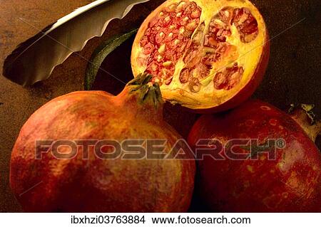 Picture - "Pomegranates, whole and half fruits". Fotosearch