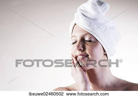 Portrait of a smiling young woman dreaming with a towel wrapped around her head View Large Photo Image Stock Image - Portrait of a smiling young woman dreaming with a towel wrapped around her head. Fotosearch