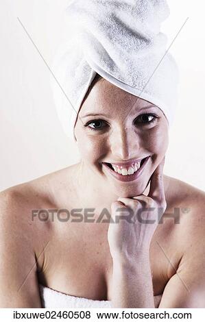 Portrait of a smiling young woman with a towel wrapped around her head View Large Photo Image Stock Photo - Portrait of a smiling young woman with a towel wrapped around her head. Fotosearch