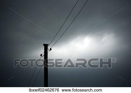 Power pole against a cloudy sky View Large Photo Image Stock Photograph - Power pole against a cloudy sky. Fotosearch