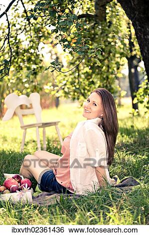 Stock Photograph - Pregnant woman in the garden. Fotosearch