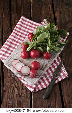 "Radishes, whole and sliced ​​on a wooden board" View Large Photo Image Picture - "Radishes, whole and sliced ​​on a wooden board". Fotosearch