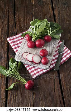Stock Photography - "Radishes, whole and sliced â€‹â€‹on a wooden board". Fotosearch