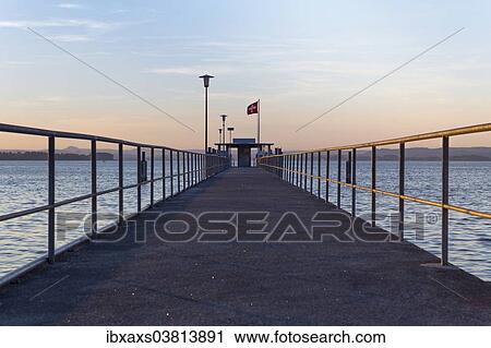 Stock Image - "Railing of the ship pier of Mannenbach in the evening light, Lake Constance, Canton of Thurgau, Switzerland, Europe". Fotosearch