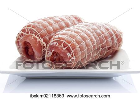 Raw pork roulade in a net on a porcelain plate View Large Photo Image Stock Photo - Raw pork roulade in a net on a porcelain plate. Fotosearch