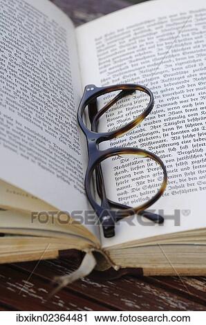 Reading glasses with a book View Large Photo Image Stock Image - Reading glasses with a book. Fotosearch