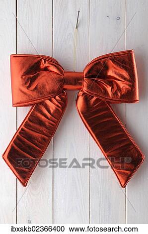 Red bow hanging on a white wooden wall View Large Photo Image Stock Image - Red bow hanging on a white wooden wall. Fotosearch