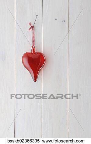Red glass heart hanging on a white wooden wall View Large Photo Image Stock Photography - Red glass heart hanging on a white wooden wall. Fotosearch