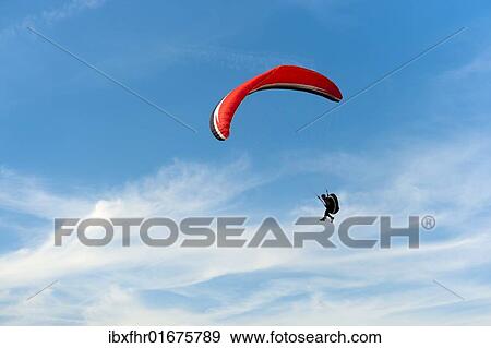 Red paraglider against a blue sky View Large Photo Image Stock Photo - Red paraglider against a blue sky. Fotosearch