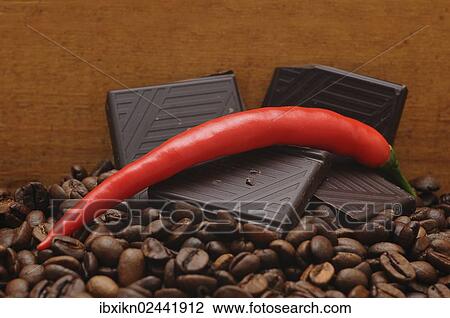 Stock Image - Red pepper and chocolate on coffee beans. Fotosearch