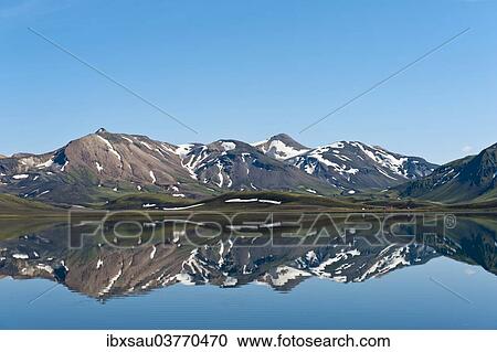 Stock Image - "Reflection in the still lake, remnants of snow, panoramic mountain landscape at Alftavatn lake, Laugavegur trekking route, Highlands, Suourland, Iceland, Europe". Fotosearch