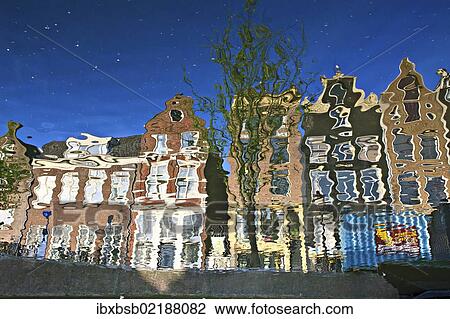 Stock Image - "Reflection of buildings in a canal in Amsterdam, Holland, Netherlands, Europe". Fotosearch