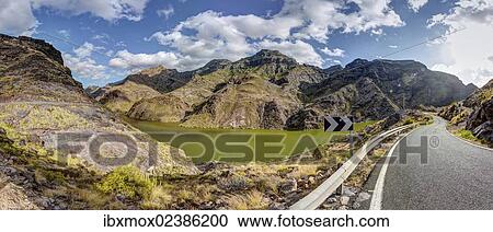 Stock Image - "Road at the Embalse Presa del Parralillo reservoir, also called """"the green lake"""", in the mountains of Caldera de Tejeda, also called a """"petrified storm"""", Artenara Region, Gran Canaria, Canary Islands, Spain, Europe, PublicGround, Europe". Fotosearch