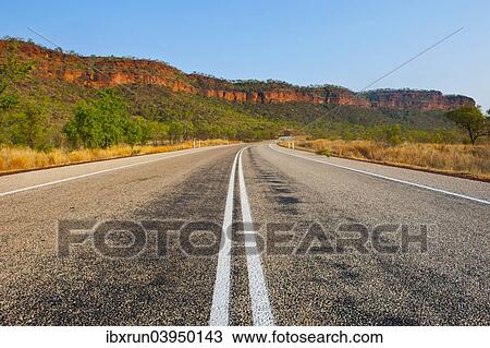 Stock Image - "Road, red cliffs, Northern Territory, Australia, Oceania". Fotosearch